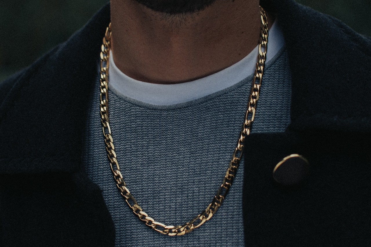 close up image of a man wearing a chunky yellow gold chain necklace