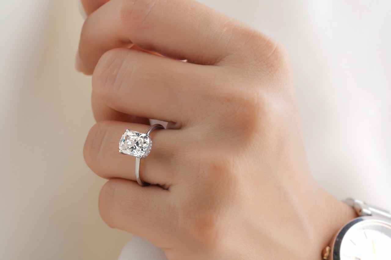 close up of a lady’s hand wearing an engagement ring