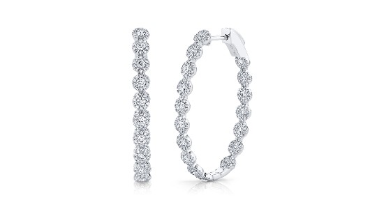 a pair of white gold hoop earrings featuring halo diamonds