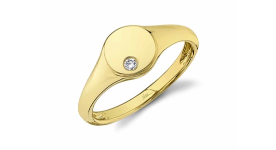 a yellow gold circle signet ring with a single round cut diamond set into it