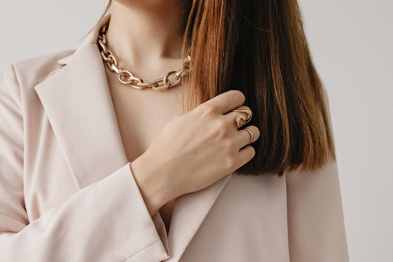 close-up of lady’s necklace and hand wearing jewelry