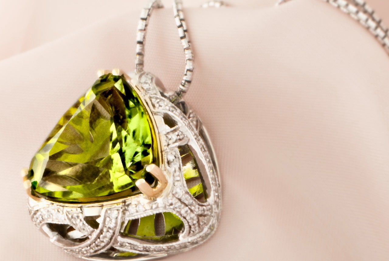 a silver, peridot pendant necklace with intricate details