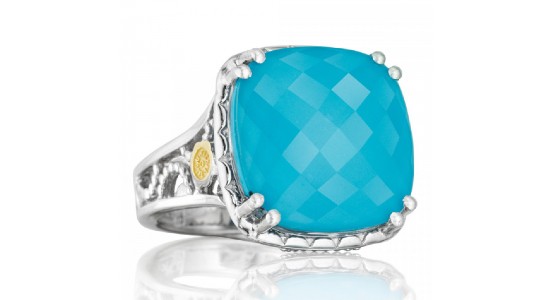 a turquoise cocktail ring with a silver setting and small yellow gold detail