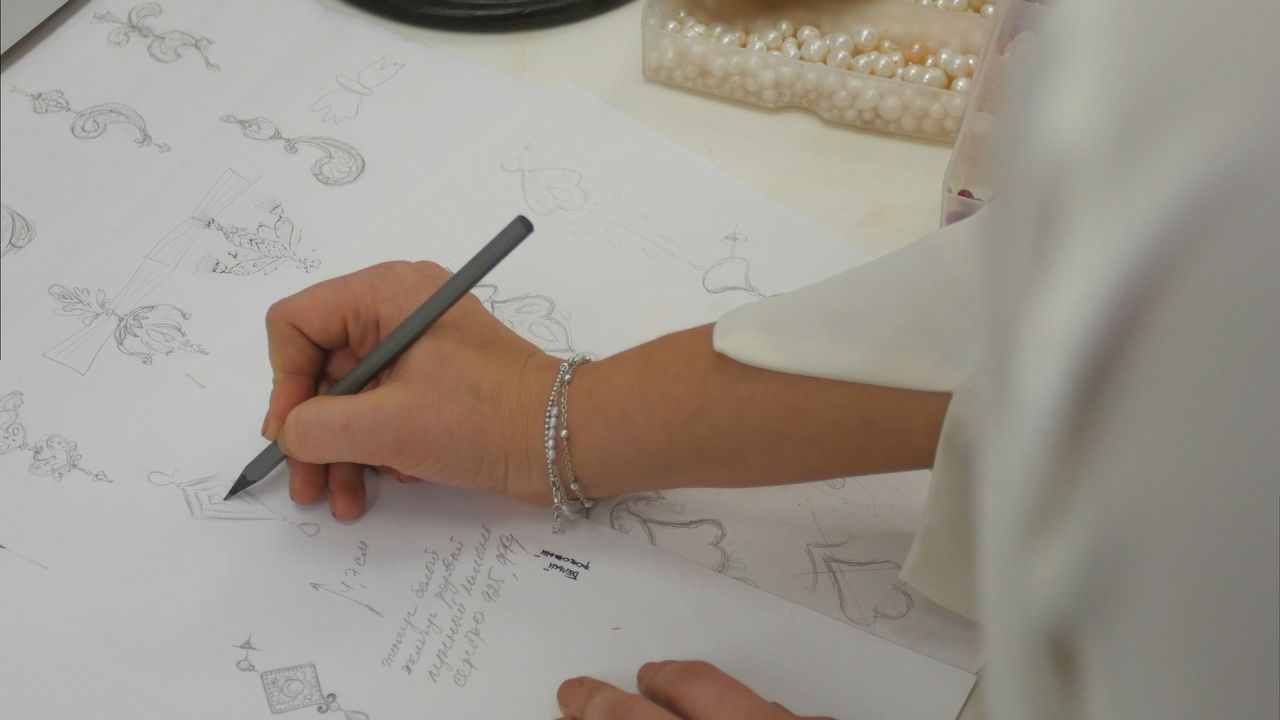 Goldsmith drafting a jewelry design.