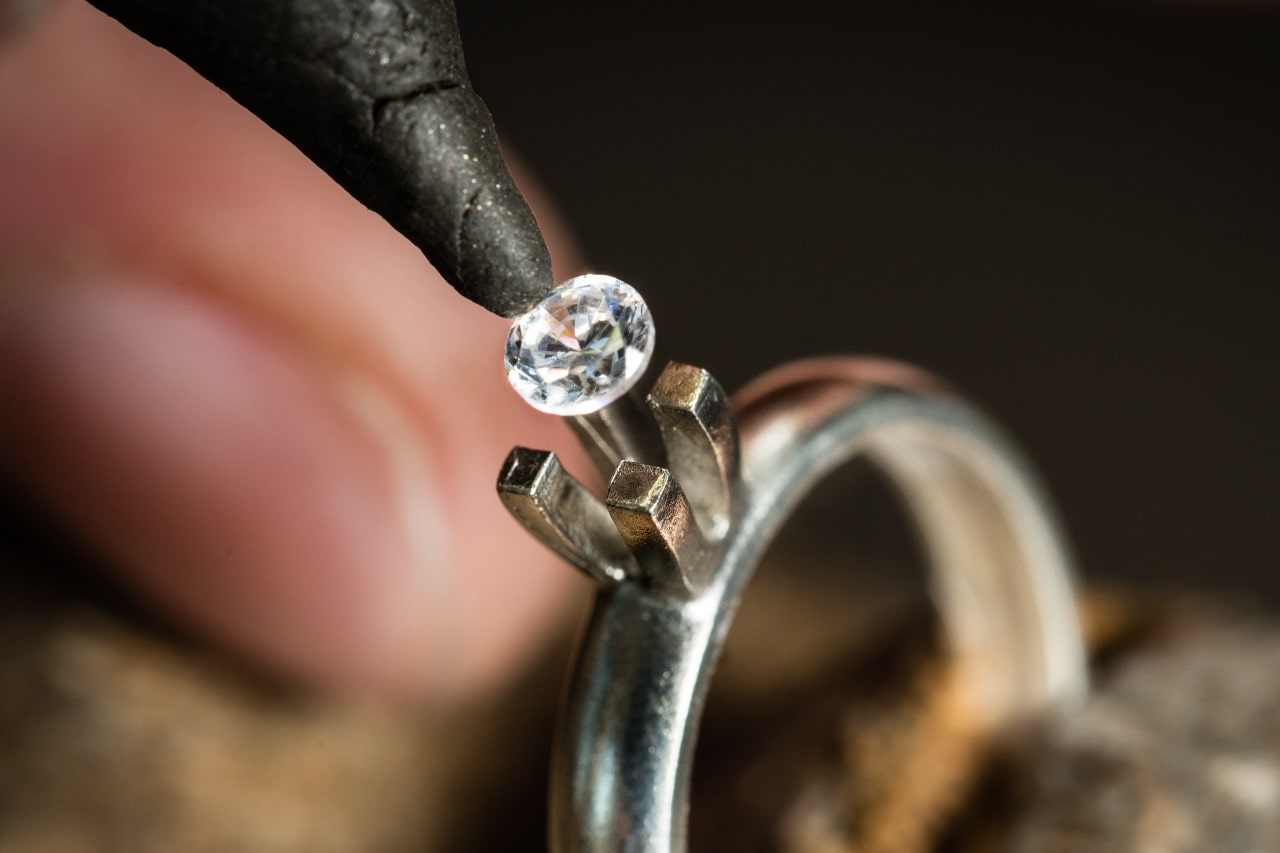 Master jeweler mounting a diamond into an engagement ring.