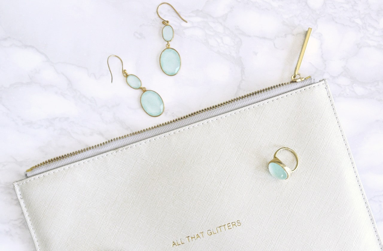 Pair of gold and topaz drop earrings alongside a fashion ring.
