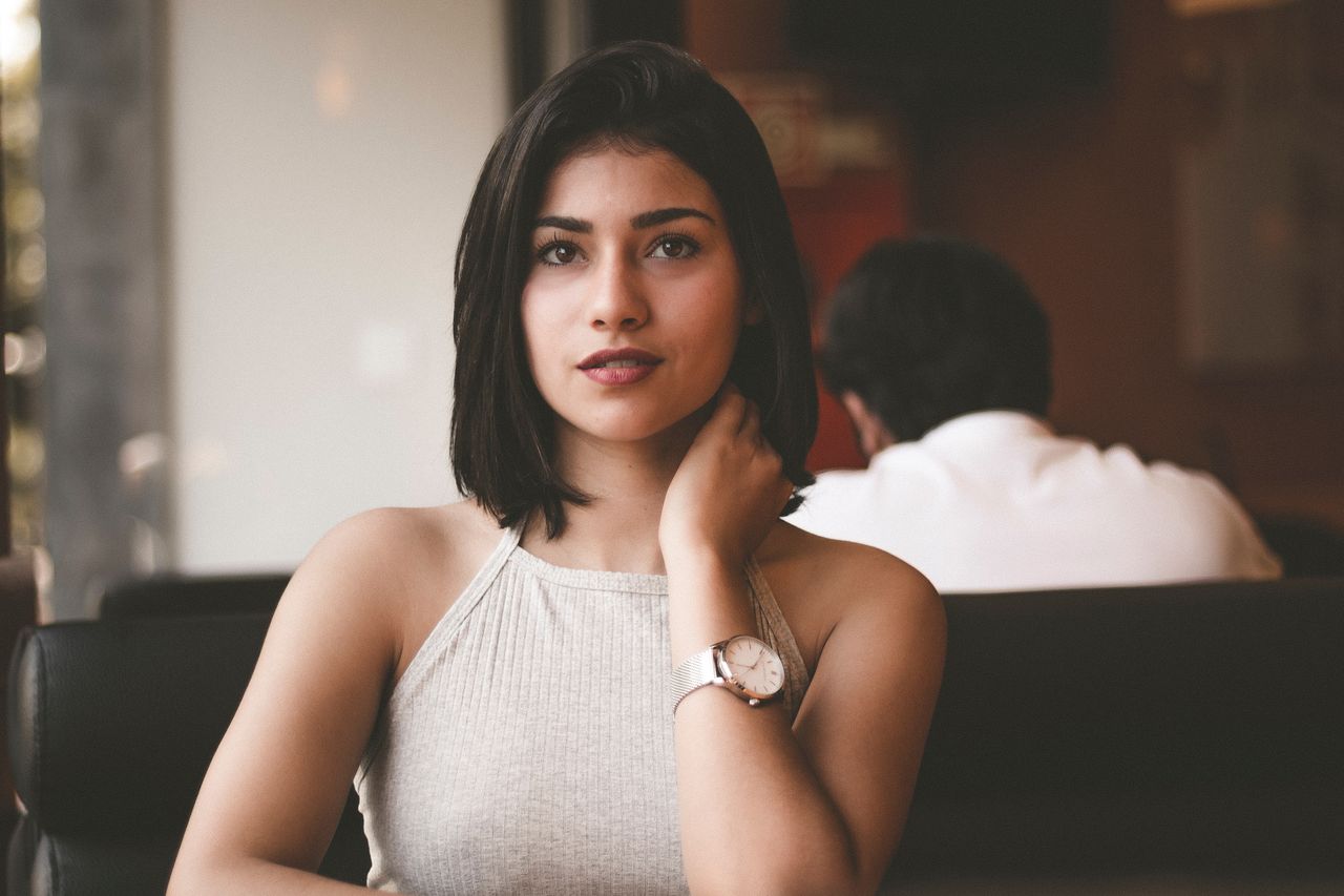 stylish lady wearing a watch and sitting in a restaurant