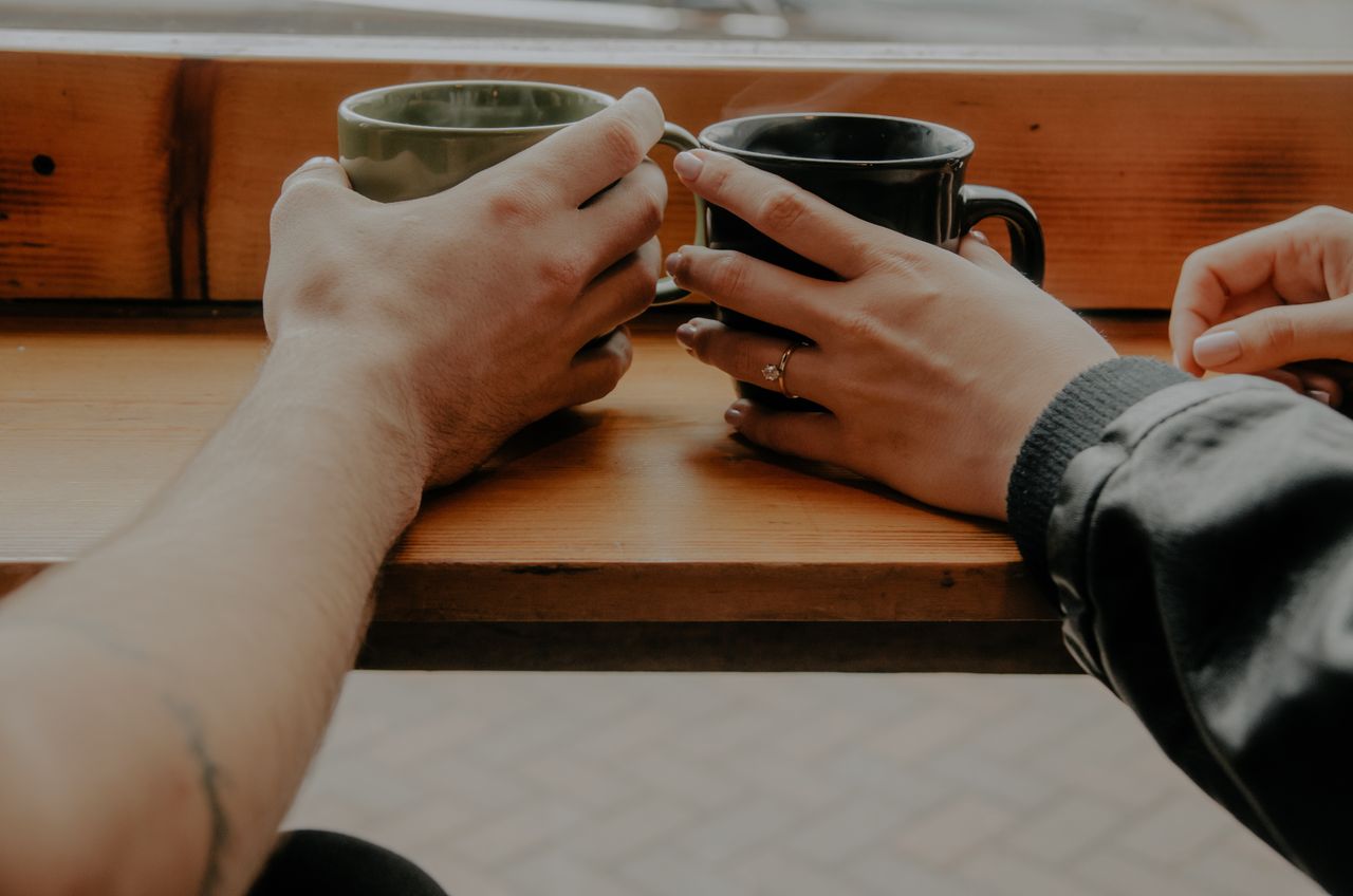 Couple drinking coffee with oval cut ring