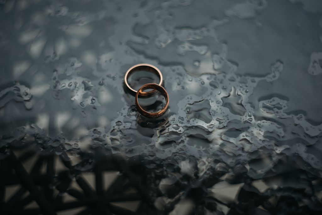 Pair of wedding bands on a wet surface.